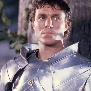 Nicholas Clay as Lancelot in John Boorman's "Excalibur" embodies the perfect knight at the height of his noble quest. Knight in polished silver armor with curly hair looking upward in heroic pose from 1981 Excalibur film.